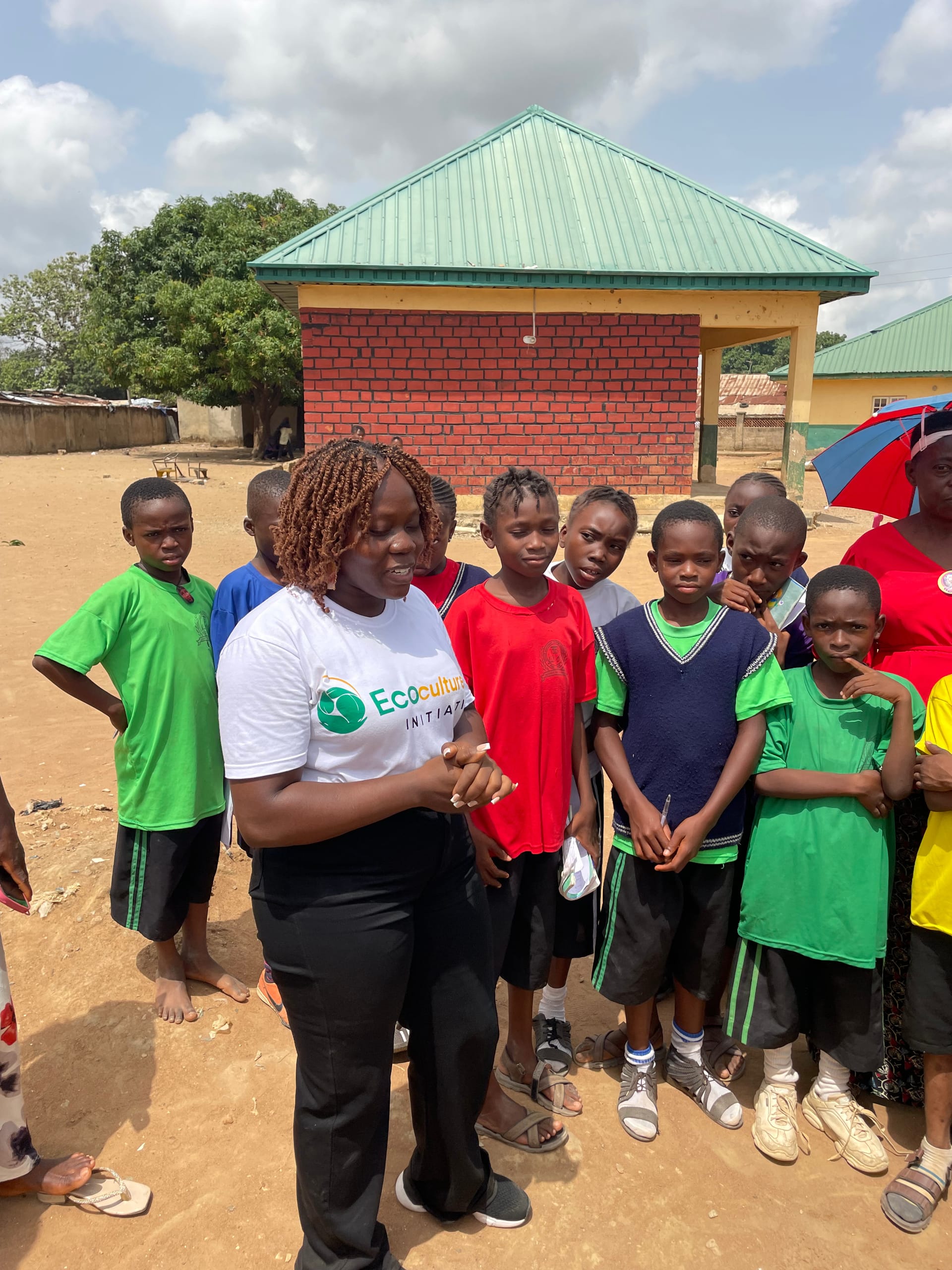 Community members planting and watering a young sapling together