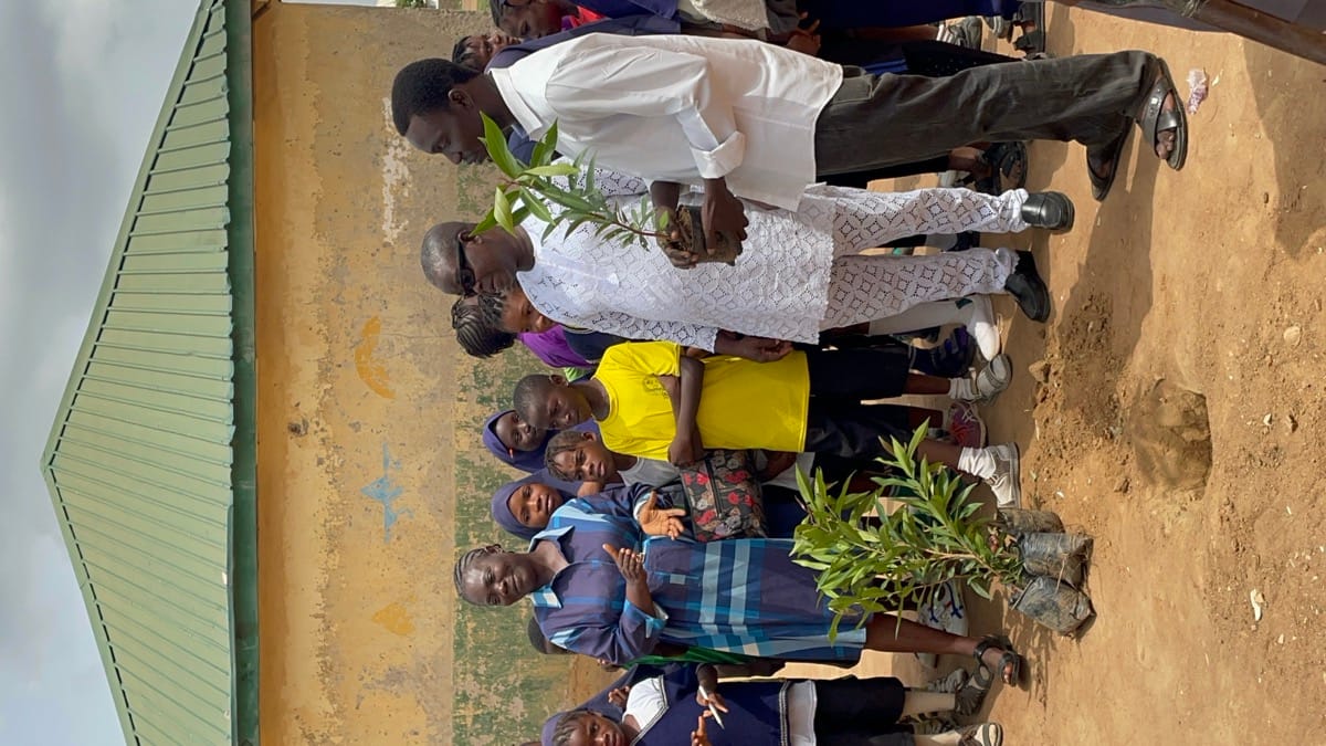 Community members holding tree saplings